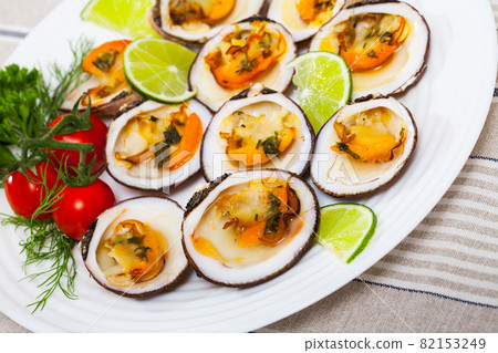 Baked in oven with sauce dog cockle with lemon and fresh greens 82153249