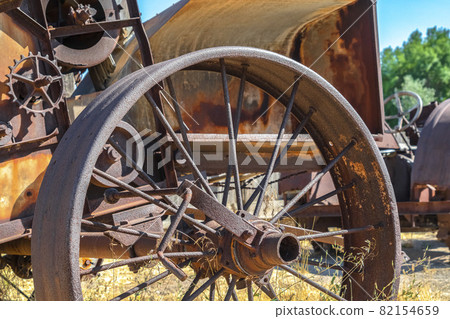 Close up of the rusty wheels of an old vintage tractor on a farm on a sunny day Close up of the rusty wheels of an old vintage tractor on a farm on a sunny day 82154659
