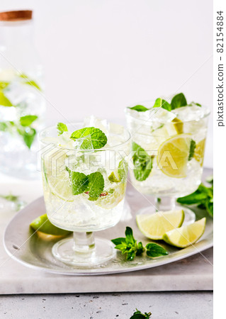 Cold refreshing summer lemonade mojito in a glass on a grey concrete or stone background. Copy space. 82154884