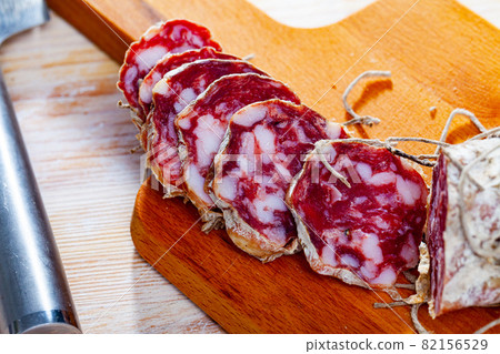 Fresh italian piacenza salami cut in slices on a wooden surface Fresh italian piacenza salami cut in slices on a wooden surface 82156529