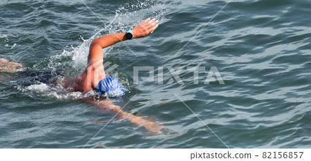 Man swimmer swimming crawl in blue sea, race for triathlon Man swimmer swimming crawl in blue sea, race for triathlon 82156857