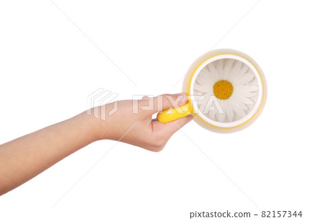 Empty yellow tea cup with chamomile flowers 82157344