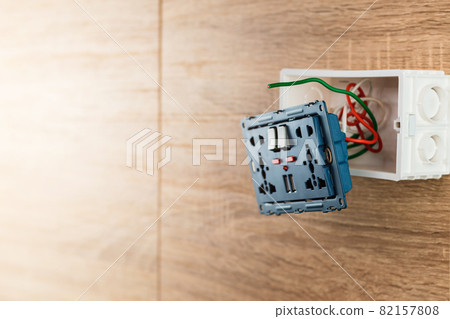 Universal wall outlet AC power plug with USB port in a plastic box on a wooden wall. Universal wall outlet AC power plug with USB port in a plastic box on a wooden wall. 82157808