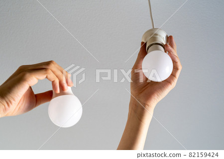 Person replacing LED bulb Person replacing LED bulb 82159424