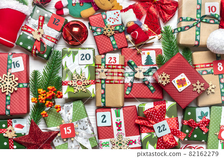 Handmade wrapped red, green gift boxes decorated with ribbons, snowflakes and numbers, Christmas decorations and decor on white table Xmas advent calendar concept Top view Flat lay Holiday card Handmade wrapped red, green gift boxes decorated with ribbons, snowflakes and numbers, Christmas decorations and decor on white table Xmas advent calendar concept Top view Flat lay Holiday card 82162279
