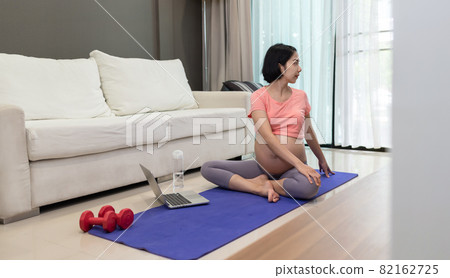 Attractive Asian young woman in sport clothing stretching on exercise mat Attractive Asian young woman in sport clothing stretching on exercise mat 82162725