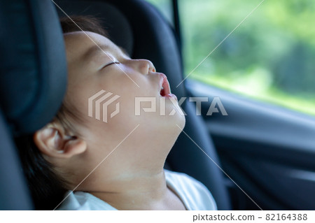 Boy sleeping in a child seat 82164388