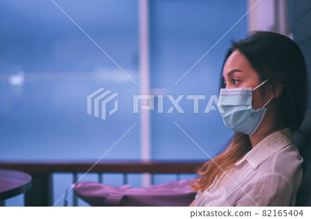 Film grain , Candid side view of young women wearing surgical protection mask be inattentive and waiting something 82165404