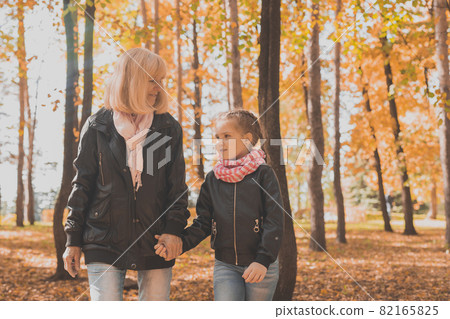Grandmother with granddaughter in autumn park. Generation and family concept. 82165825