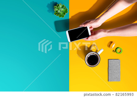Person using a white smartphone Person using a white smartphone 82165993