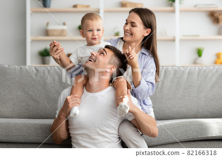 Happy Family Portrait. Cheerfu parents with infant son having fun at home 82166318