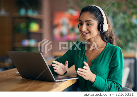 Attractive indian lady having video call at cafe Attractive indian lady having video call at cafe 82166331