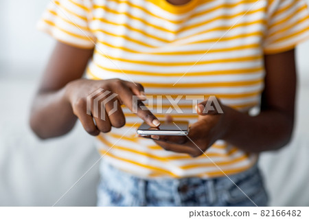 Unrecognizable black woman using brand new mobile phone 82166482