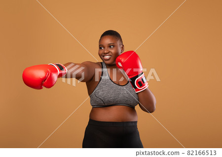 Young Black Woman Boxing Wearing Red Gloves Throwing Punch 82166513
