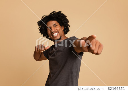 Joyful Young African American Guy Poiting At Camera With Two Hands Joyful Young African American Guy Poiting At Camera With Two Hands 82166851