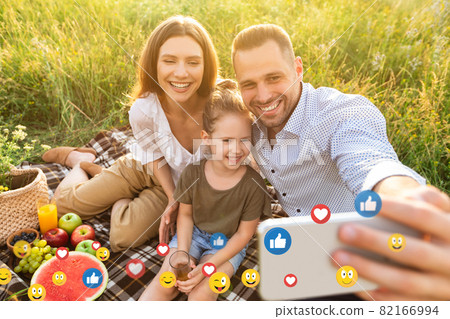 Happy young european family with little daughter on picnic taking selfie for social networks outdoor Happy young european family with little daughter on picnic taking selfie for social networks outdoor 82166994