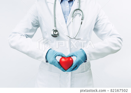 female doctor in white uniform creates heart shape with hands female doctor in white uniform creates heart shape with hands 82167502