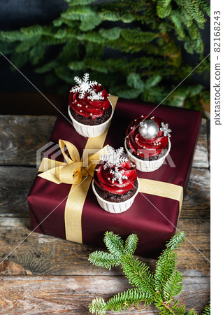 Tasty homemade festive Christmas muffin or cupcake with cream and sweet balls and snowflakes Tasty homemade festive Christmas muffin or cupcake with cream and sweet balls and snowflakes 82168243