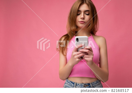 Photo shot of concentrated attractive positive good looking young woman wearing casual stylish Photo shot of concentrated attractive positive good looking young woman wearing casual stylish 82168517