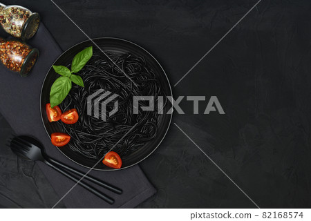 Black pasta set with tomato, basil and seasonings. 82168574