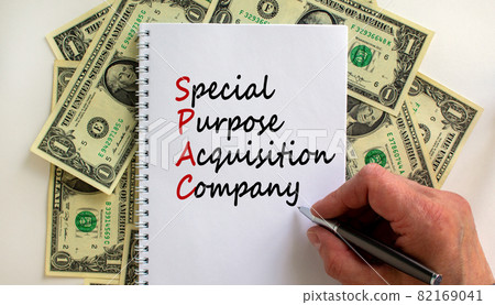 SPAC, special purpose acquisition company symbol. Word SPAC on beautiful white background, copy space. Businessman hand, dollar bills. Business and SPAC, special purpose acquisition company concept. 82169041