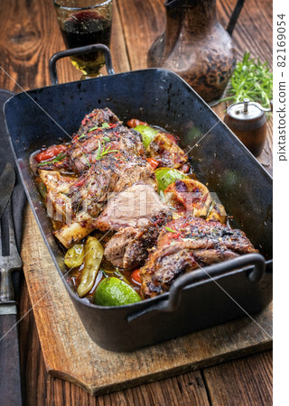 barbecue leg of lamb with lemon and tomatoes  82169054