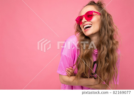 Attractive happy smiling young blonde woman wearing everyday stylish clothes and modern sunglasses Attractive happy smiling young blonde woman wearing everyday stylish clothes and modern sunglasses 82169077