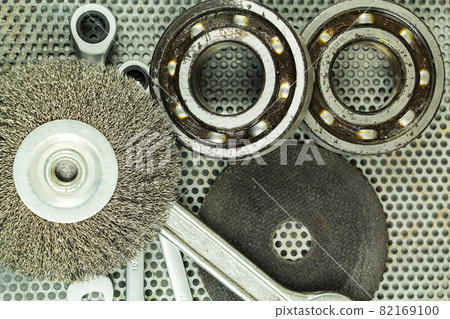 Metalworking tools, steel parts, a wrench, on the background of a metal lattice. Metalworking tools, steel parts, a wrench, on the background of a metal lattice. 82169100