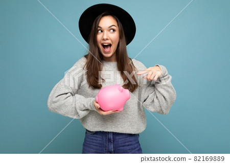 Portrait of happy positive surpeised young beautiful brunette woman wearing stylish gray sweater and Portrait of happy positive surpeised young beautiful brunette woman wearing stylish gray sweater and 82169889