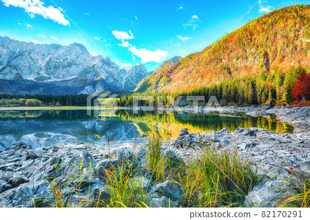 Fairytale view of Fusine lake with Mangart peak on background Fairytale view of Fusine lake with Mangart peak on background 82170291