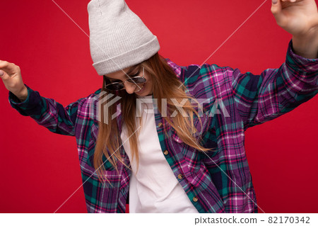 Fantastic photo shot of beautiful young dark blonde woman isolated over red background wearing Fantastic photo shot of beautiful young dark blonde woman isolated over red background wearing 82170342