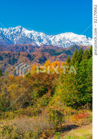 Three-tiered autumn leaves in the Northern Alps seen from Ogawa Village [Nagano Prefecture] 82170662