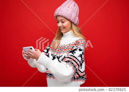 Side-profile Photo of beautiful smiling young blonde woman wearing warm knitted hat and winter warm Side-profile Photo of beautiful smiling young blonde woman wearing warm knitted hat and winter warm 82170925