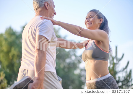 A mid aged couple stretching before the morning workout A mid aged couple stretching before the morning workout 82171107