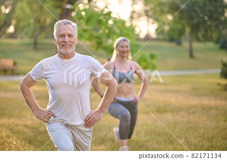 A mid aged couple having a workout in the park 82171134