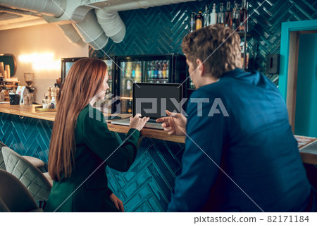 Back view of man and woman sitting near laptop Back view of man and woman sitting near laptop 82171184