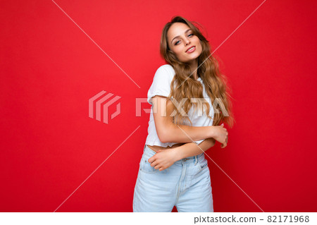 Young beautiful blond woman wearing white t-shirt looking at camera. Positive female shows facial Young beautiful blond woman wearing white t-shirt looking at camera. Positive female shows facial 82171968