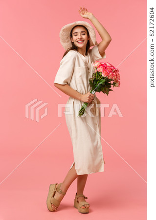 Full-length vertical portrait romantic upbeat, enthusiastic gorgeous woman feeling excitement and joy, enjoying weekends, leisure on summer resort, dancing receiving bouquet roses 82172604