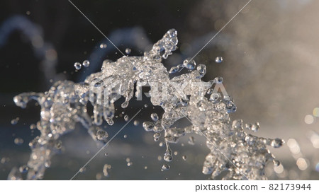 Beautiful fountain on a bright sunny day in slow motion. Jets of water sparkle in the sun. Bright splashes slowly spread to the sides. 82173944