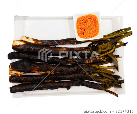 Calcots onions served on plate with Romesco sauce - traditional Catalan dish Calcots onions served on plate with Romesco sauce - traditional Catalan dish 82174315