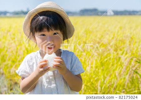 A girl chewing onigiri 82175024
