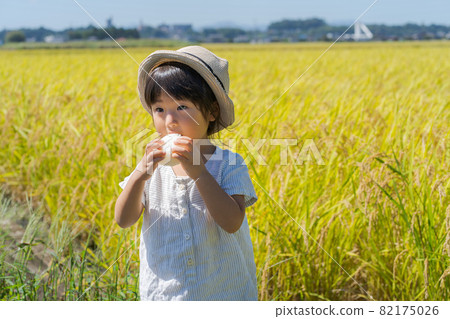 A girl chewing onigiri 82175026