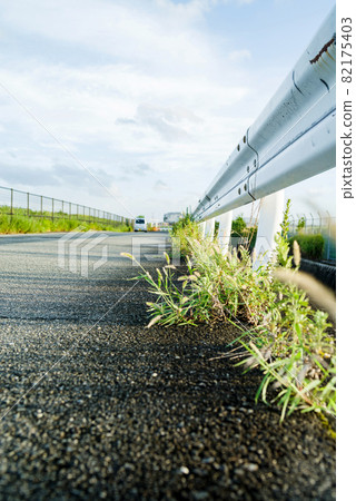 瀝青路面和路邊的雜草和護欄 瀝青路面和路邊的雜草和護欄 82175403