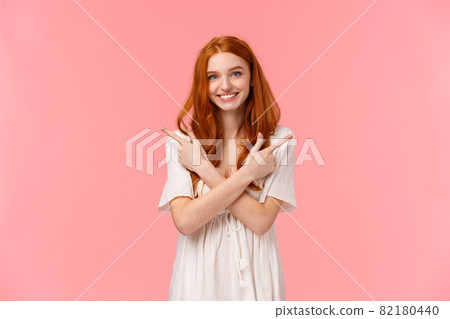 Waist-up portrait lovely feminine, sensual redhead woman in white dress, asking your opinion, showing two variants, cross hands over body and pointing left and right banners, smiling friendly 82180440