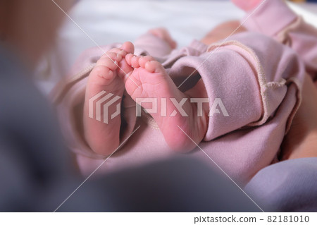 Newborn feets of caucasian newborn girl. Close-up. Newborn feets of caucasian newborn girl. Close-up. 82181010