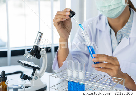 Scientist wear lab coat and protective wear are working with research or doing investigations with test tubes in experiment, Laboratory and development concept 82183109