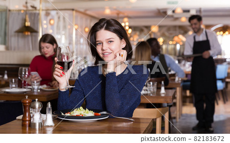 Happy girl alone in restaurant 82183672