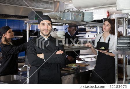 Smiling chef cook is posing on kitchen 82183673
