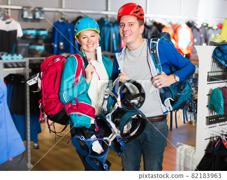 Sports couple is choosing travel gear in shop 82183963