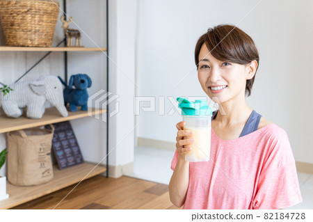 Woman drinking protein at home 82184728